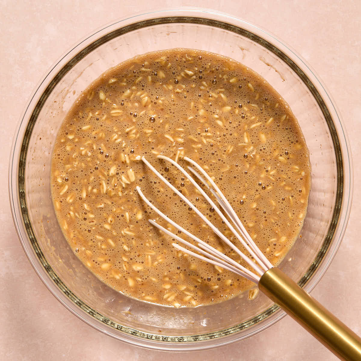 Wet muffin ingredients whisked together in a glass bowl.