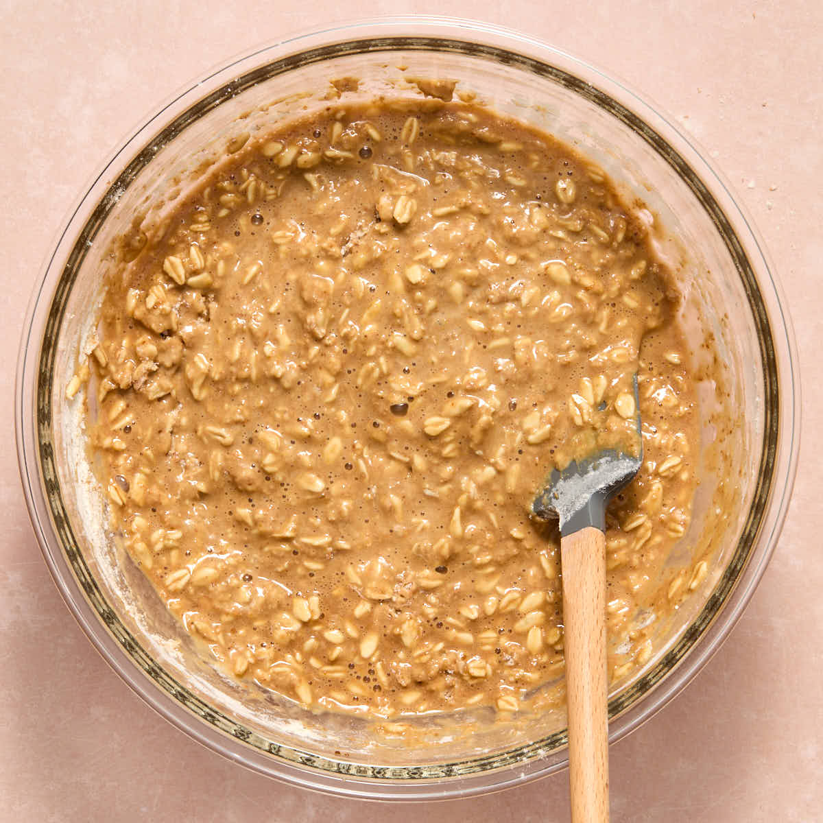 Dry ingredients stirred into the wet ingredients with a spatula.
