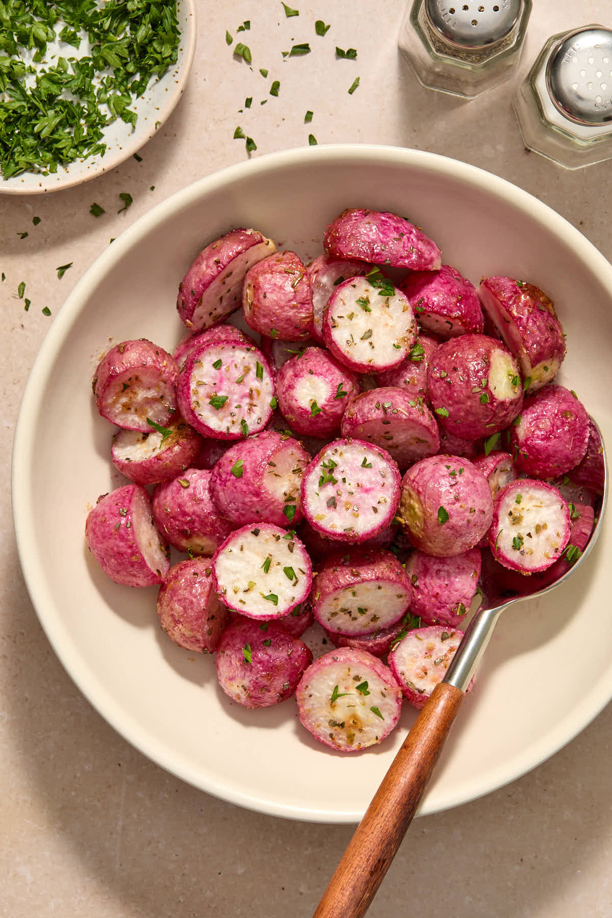 Radishes served in a bowl and garnished with chopped parsley.