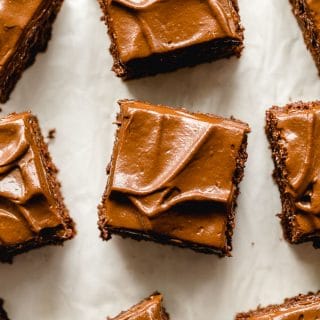 Healthy chocolate zucchini cake topped with avocado frosting and cut into squares.