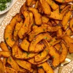 Close up of air fryer pumpkin fries served on a platter with parsley on the side.