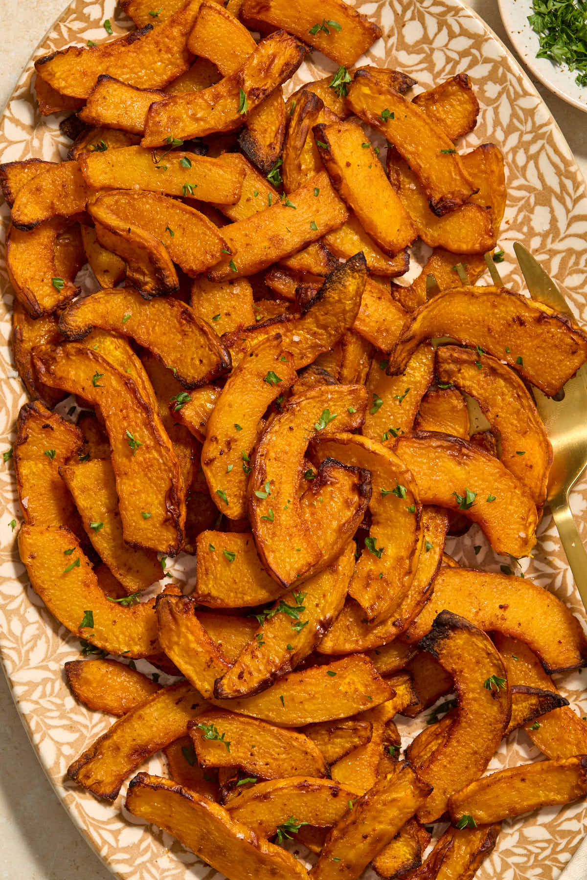 Pumpkin fries on a platter with a serving fork.