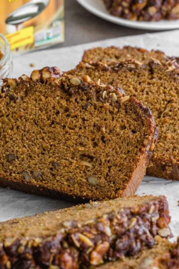 Side view of slices of walnut molasses banana bread arranged on crumpled parchment paper.
