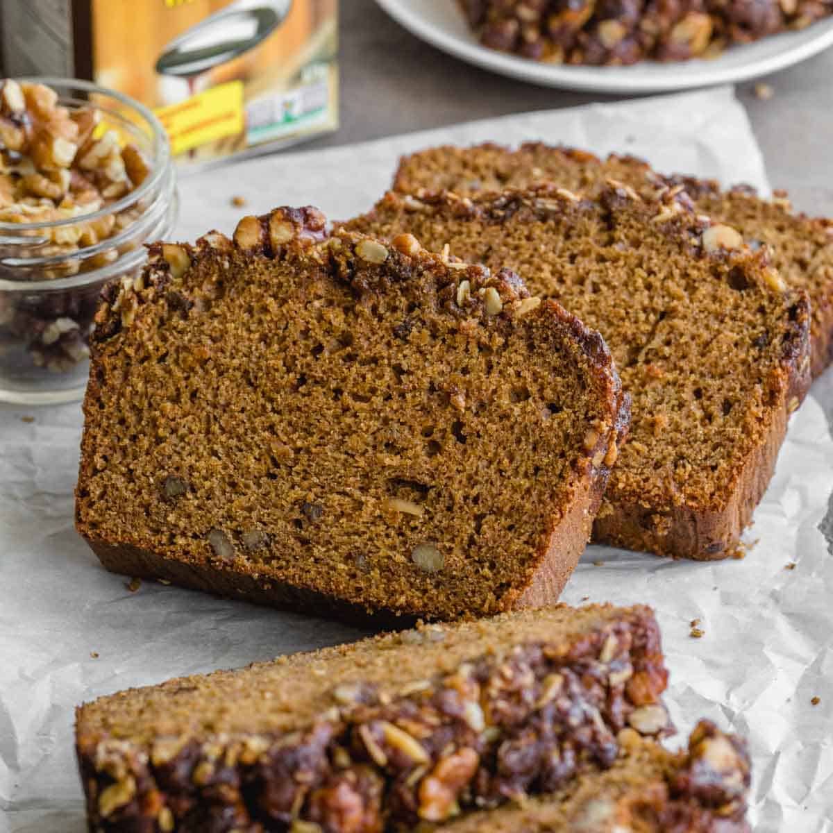 Side view of slices of walnut molasses banana bread arranged on crumpled parchment paper.