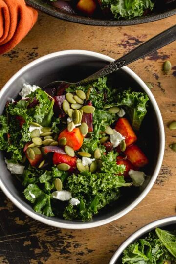 Overhead of root vegetable kale salad in a bowl with a fork.