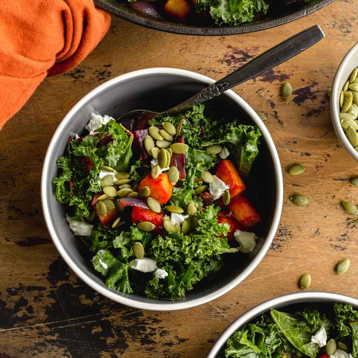 Overhead of root vegetable kale salad in a bowl with a fork.