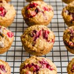 Cranberry oatmeal muffins arranged on a wire rack to cool.