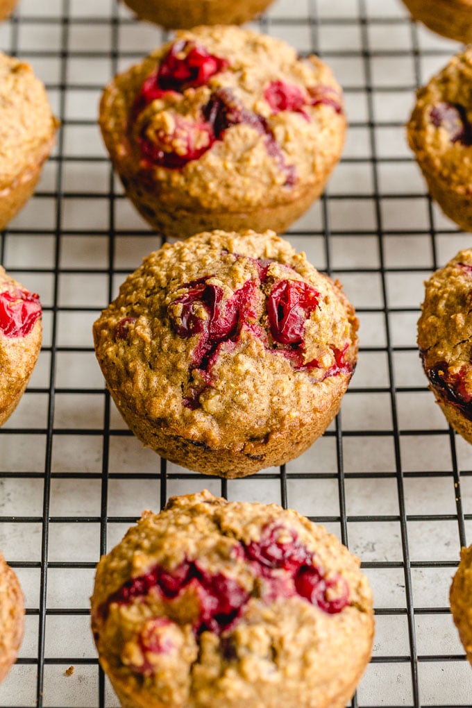 Up close view of cranberry muffins on a wire rack.