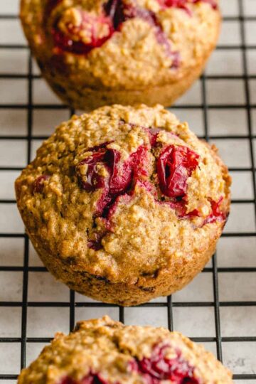 Cranberry orange oatmeal muffins arranged on a wire cooling rack.