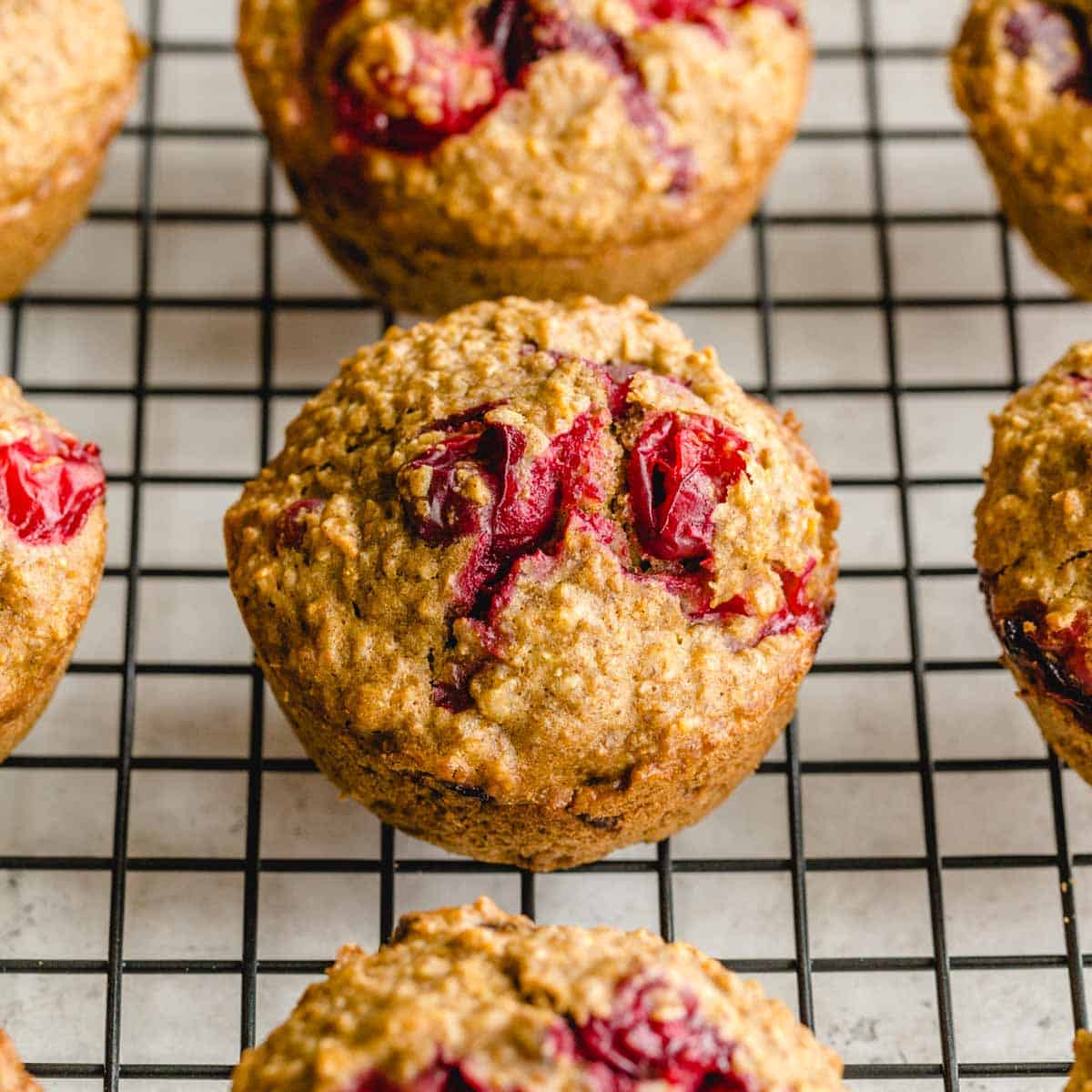 Cranberry orange oatmeal muffins arranged on a wire cooling rack.