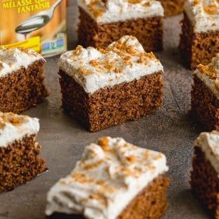 Easy Gingerbread Cake cut into squares and arranged on a grey surface.