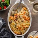 Overhead of ground turkey sweet potato casserole in a white oval dish with some scooped out with a spoon.