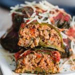 Stuffed Collard Greens cut in half and arranged on top of each other on a small plate.