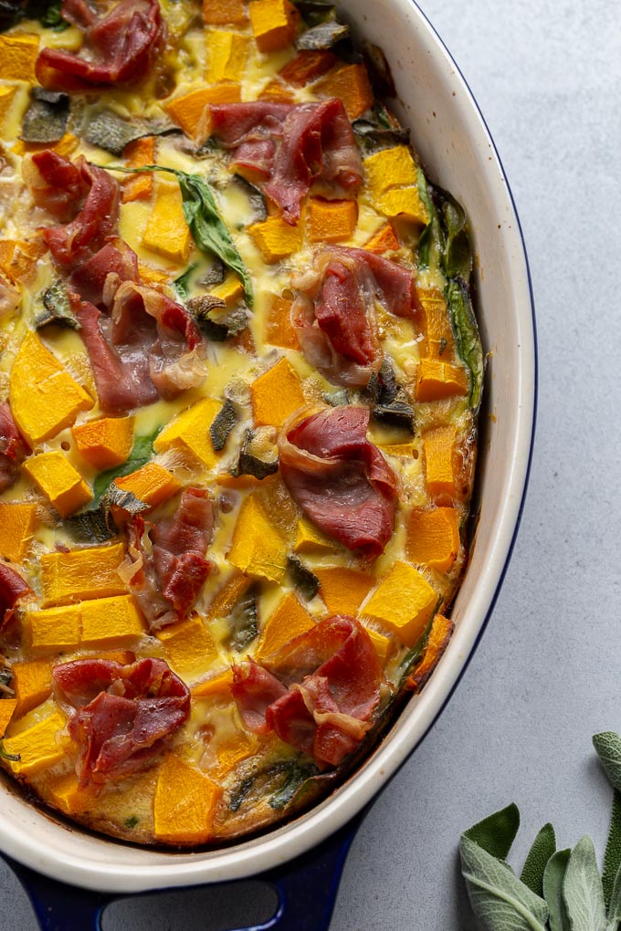 Up-close view of butternut squash quiche with crispy prosciutto on top.