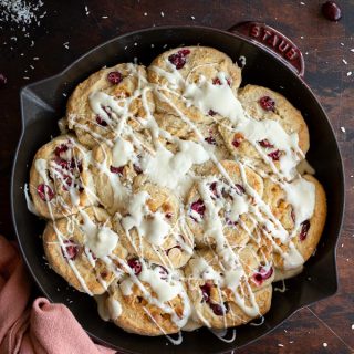Overhead view of cranberry white chocolate rolls baked up in a skillet.