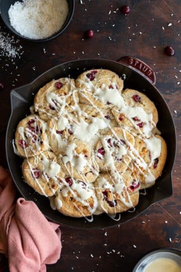 Overhead view of cranberry white chocolate rolls baked up in a skillet.
