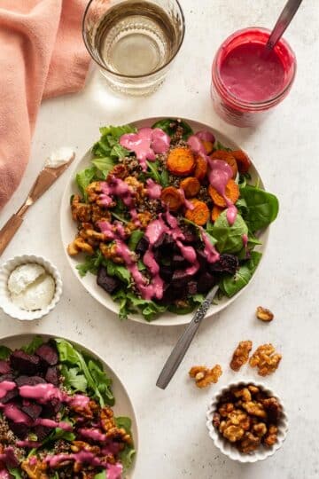 Roasted Beet and Carrot Salad arranged on plates and topped with cranberry salad dressing.