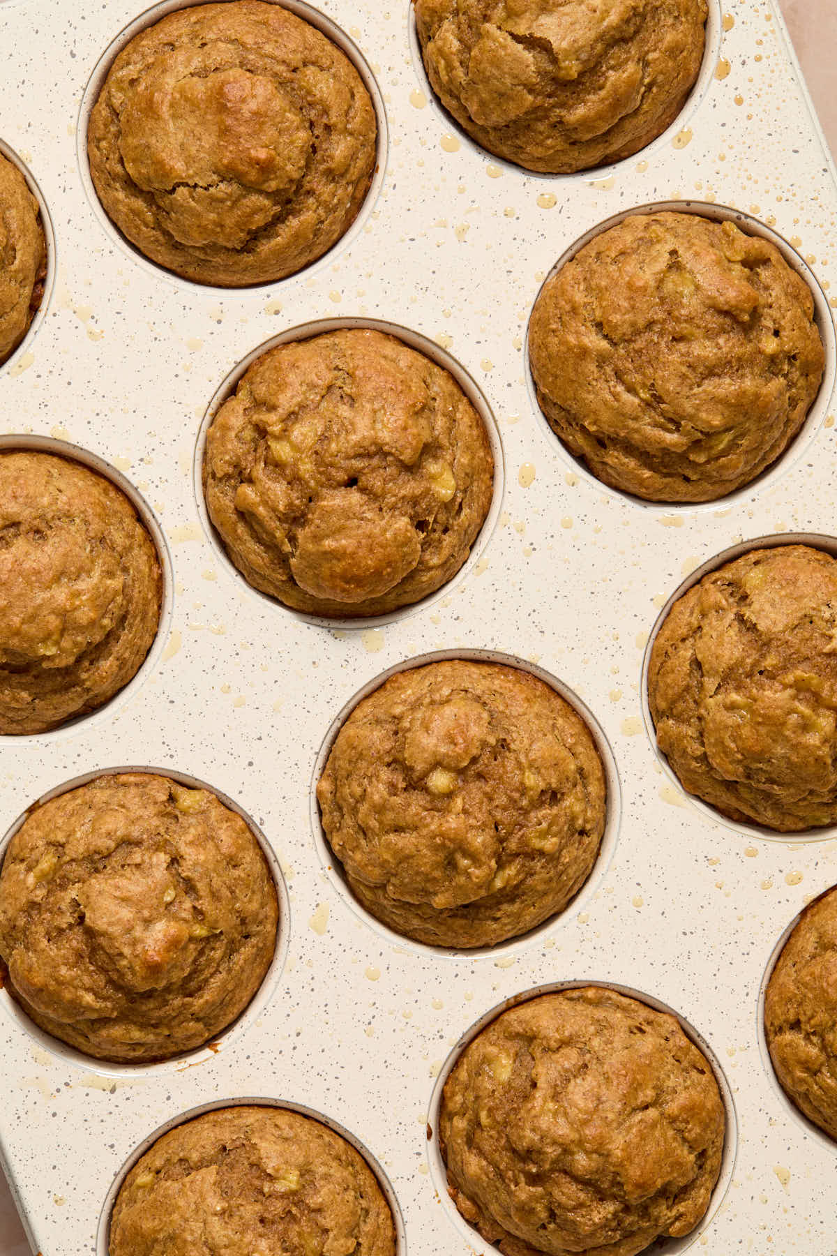Muffins baked in a white muffin pan.