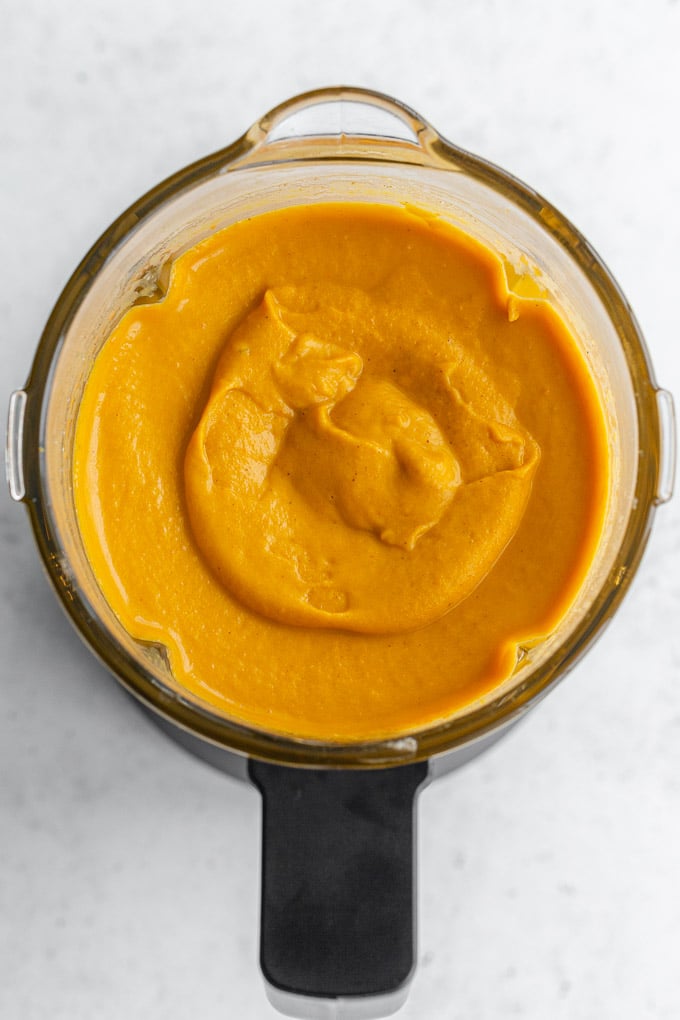 Overhead view of sweet potato carrot soup puréed in a blender jar.