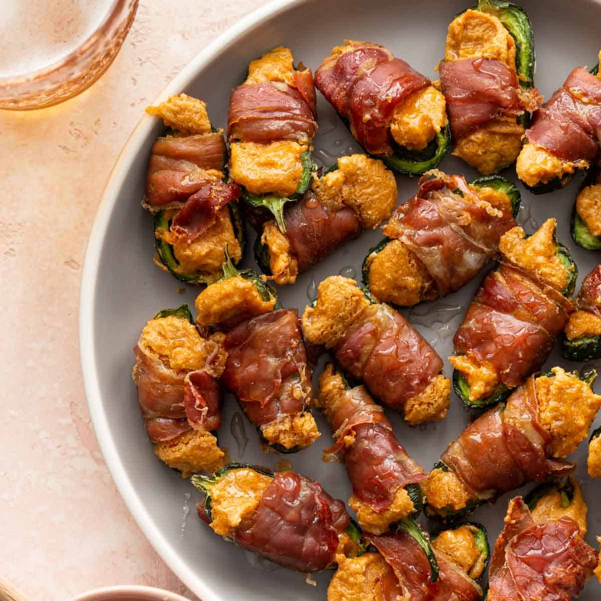 Overhead of air fryer jalapeno poppers on a grey plate.