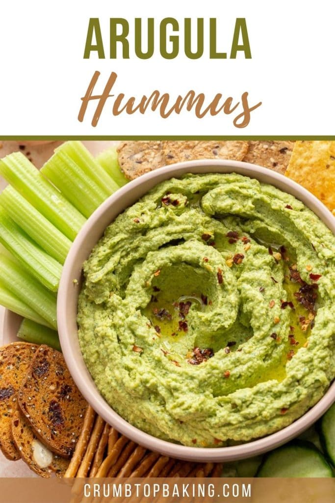 Pinterest image of arugula hummus in a pink bowl.