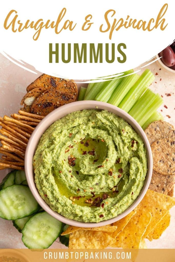 Pinterest image of green hummus in a bowl with veggies and chips on the side.