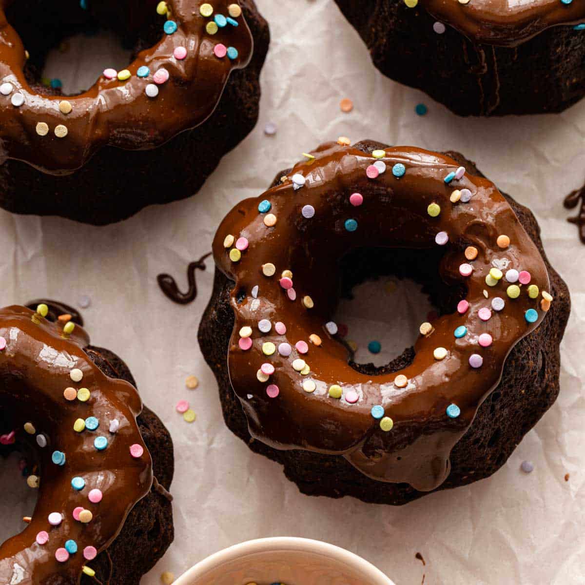 Overhead of mini chocolate bundt cakes topped with sprinkles.