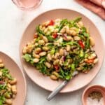 Overhead of tuna white bean salad on a pink plate with a fork.
