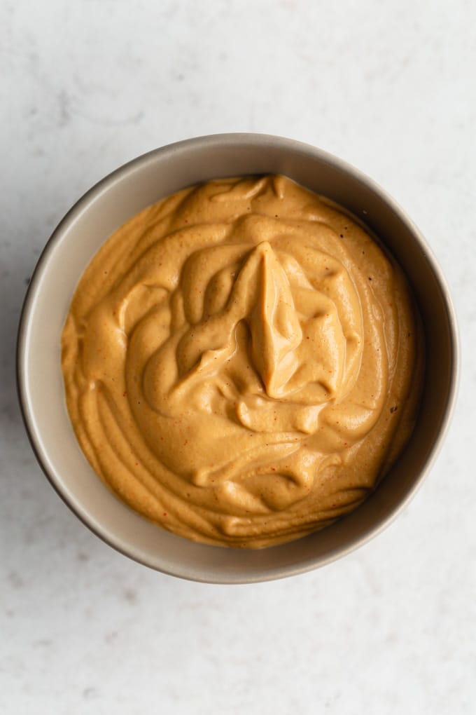 Close up overhead view of the cashew cheese sauce in a small grey bowl.