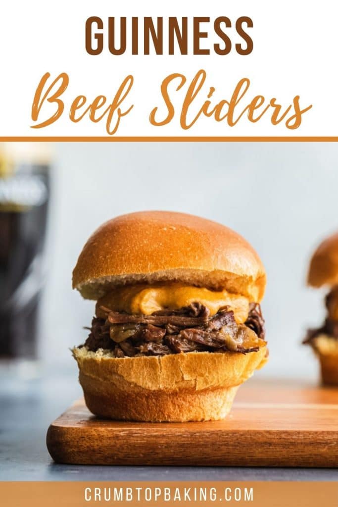 Pinterest image of an up close Guinness beef slider on a wooden board.