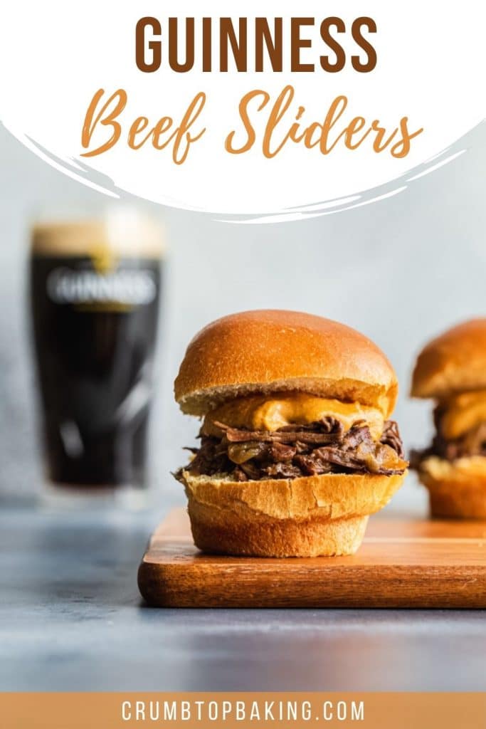 Pinterest image of Guinness beef sliders arranged on a cutting board with a glass of Guinness in background.