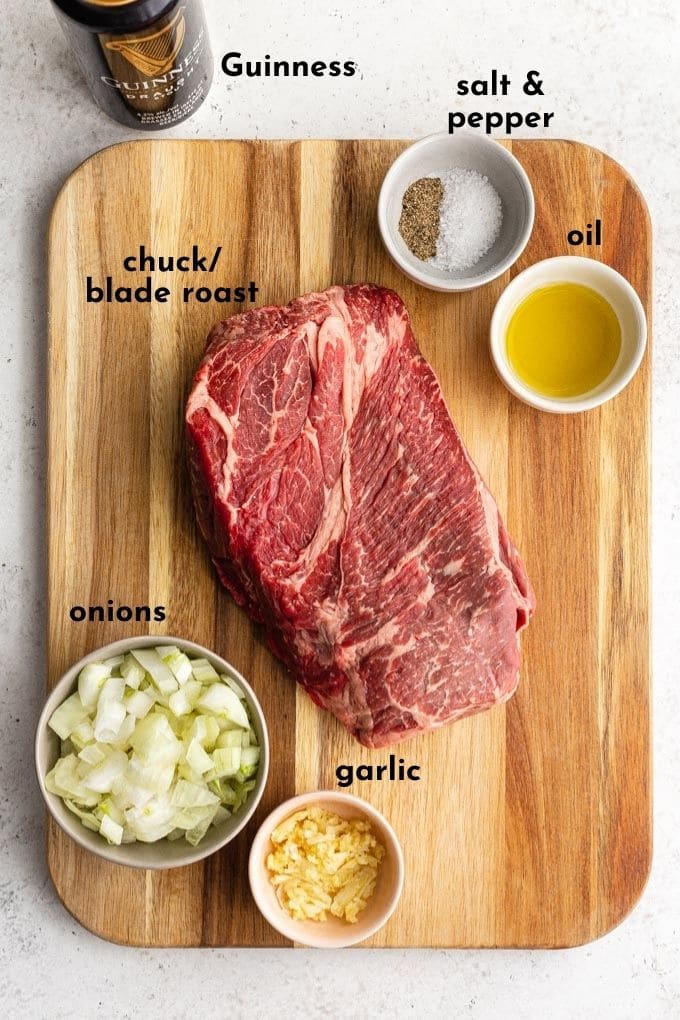 Ingredients to make Guinness braised beef arranged individually on a wooden cutting board and labelled.