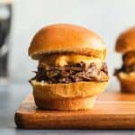 Side view of a Guinness braised beef slider on a wooden board.