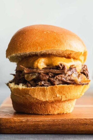Side view of a Guinness braised beef slider on a wooden board.