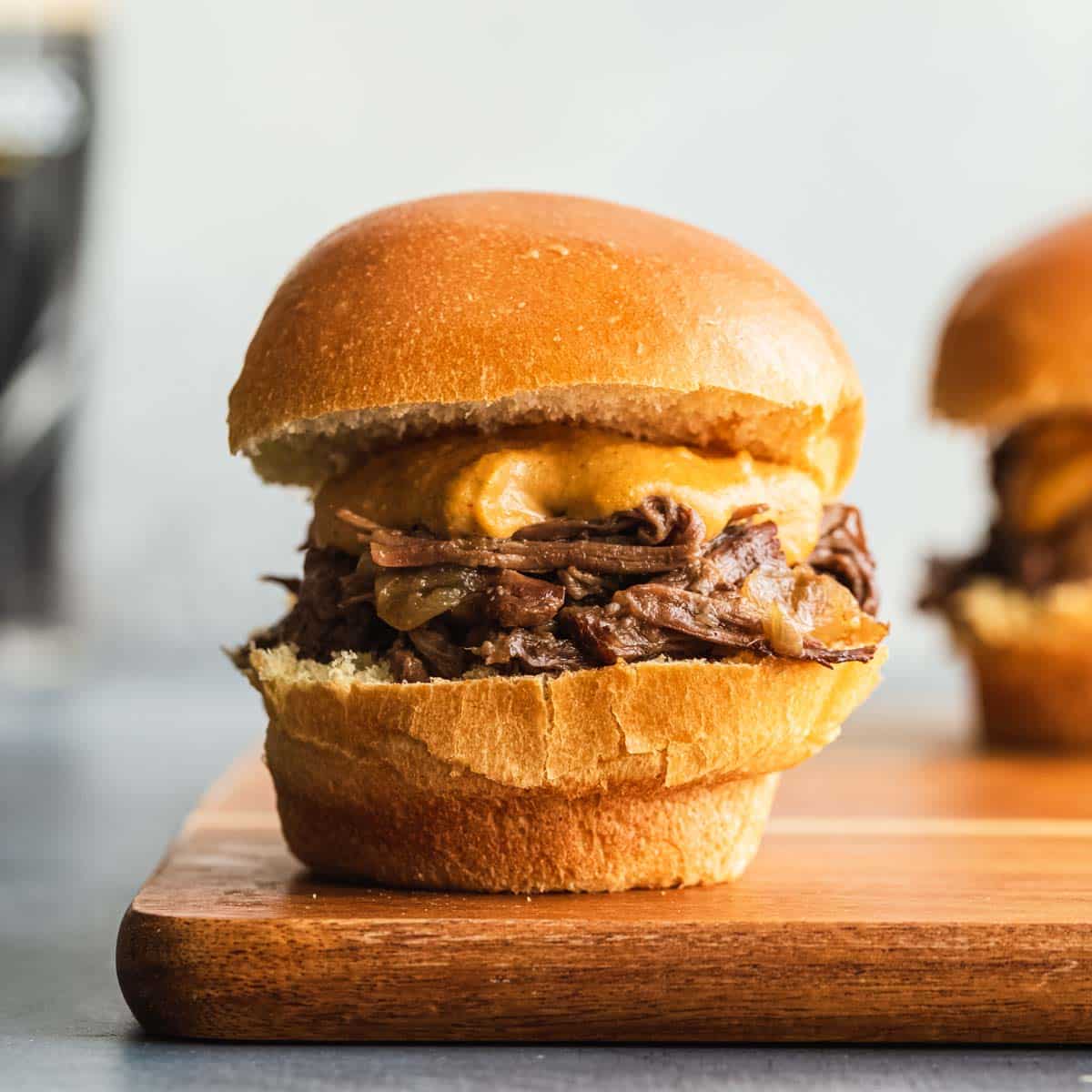 Side view of a Guinness braised beef slider on a wooden board.