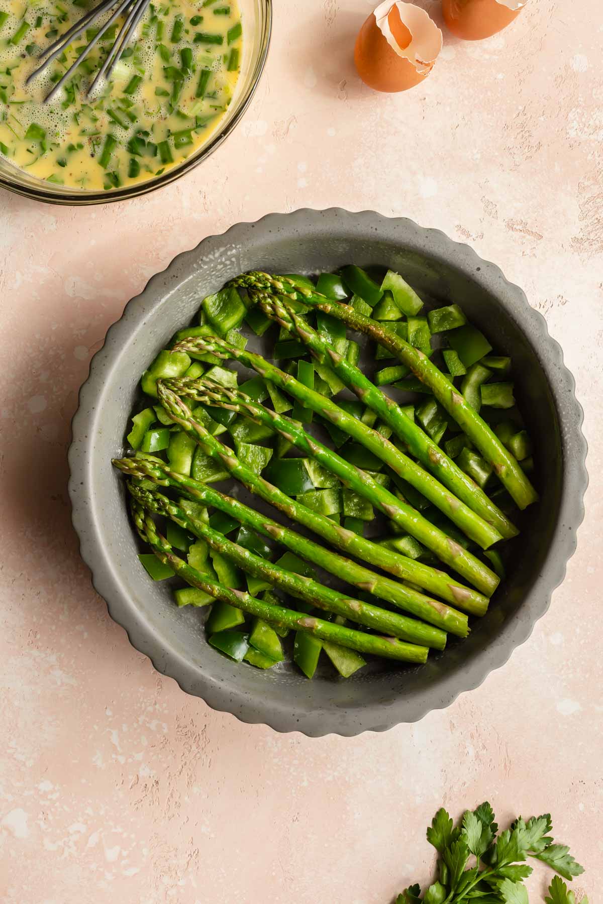 Green pepper and asparagus spears arranged in a pie plate.