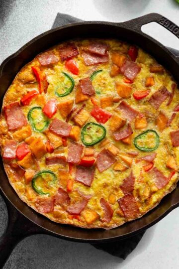 Overhead of sweet potato frittata in a black cast iron skillet.