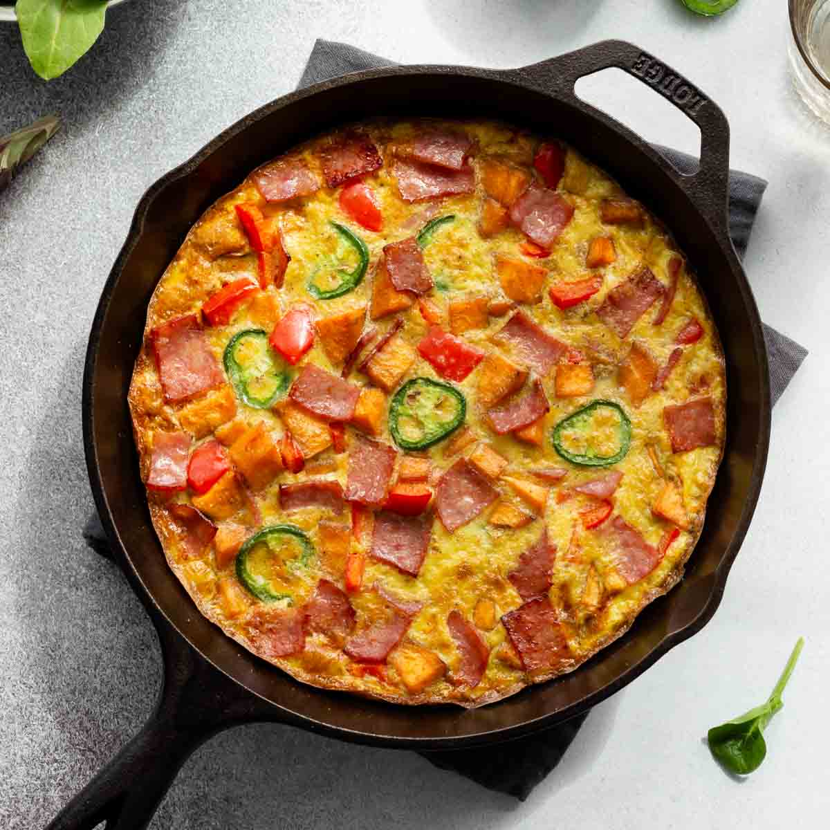 Overhead of sweet potato frittata in a black cast iron skillet.