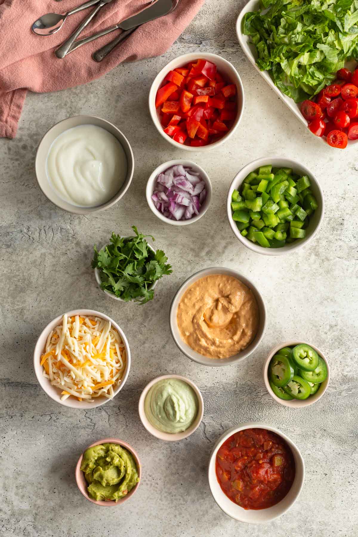 An assortment of taco toppings arranged in individual bowls.