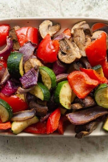Overhead view of air fryer vegetables on a rectangular plate.