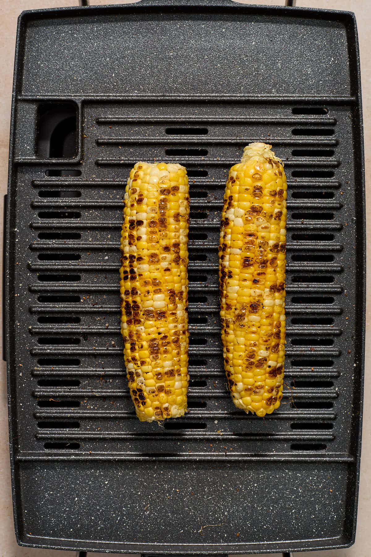 Charred ears of corn on a grill.