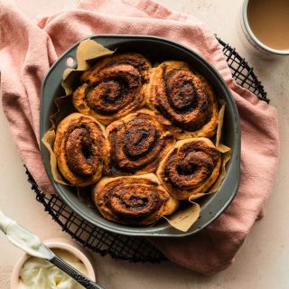 Overhead view of air fried cinnamon rolls in a round cake pan.