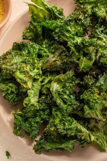 Air Fryer Kale Chips arranged on a pink plate.