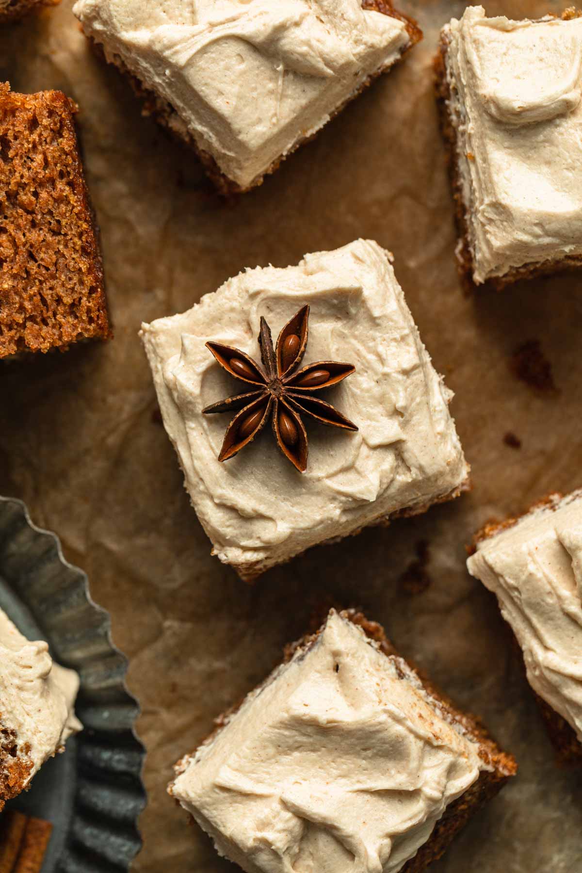 Overhead of a piece of apple spice cake with star anise arranged on top of the frosting.