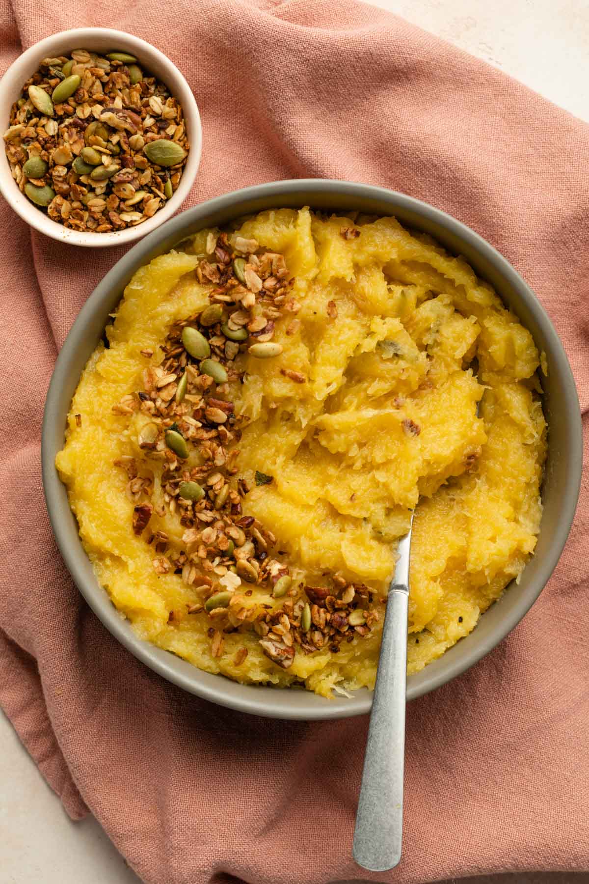 Up close overhead view of acorn squash mash in a bowl with a spoon.
