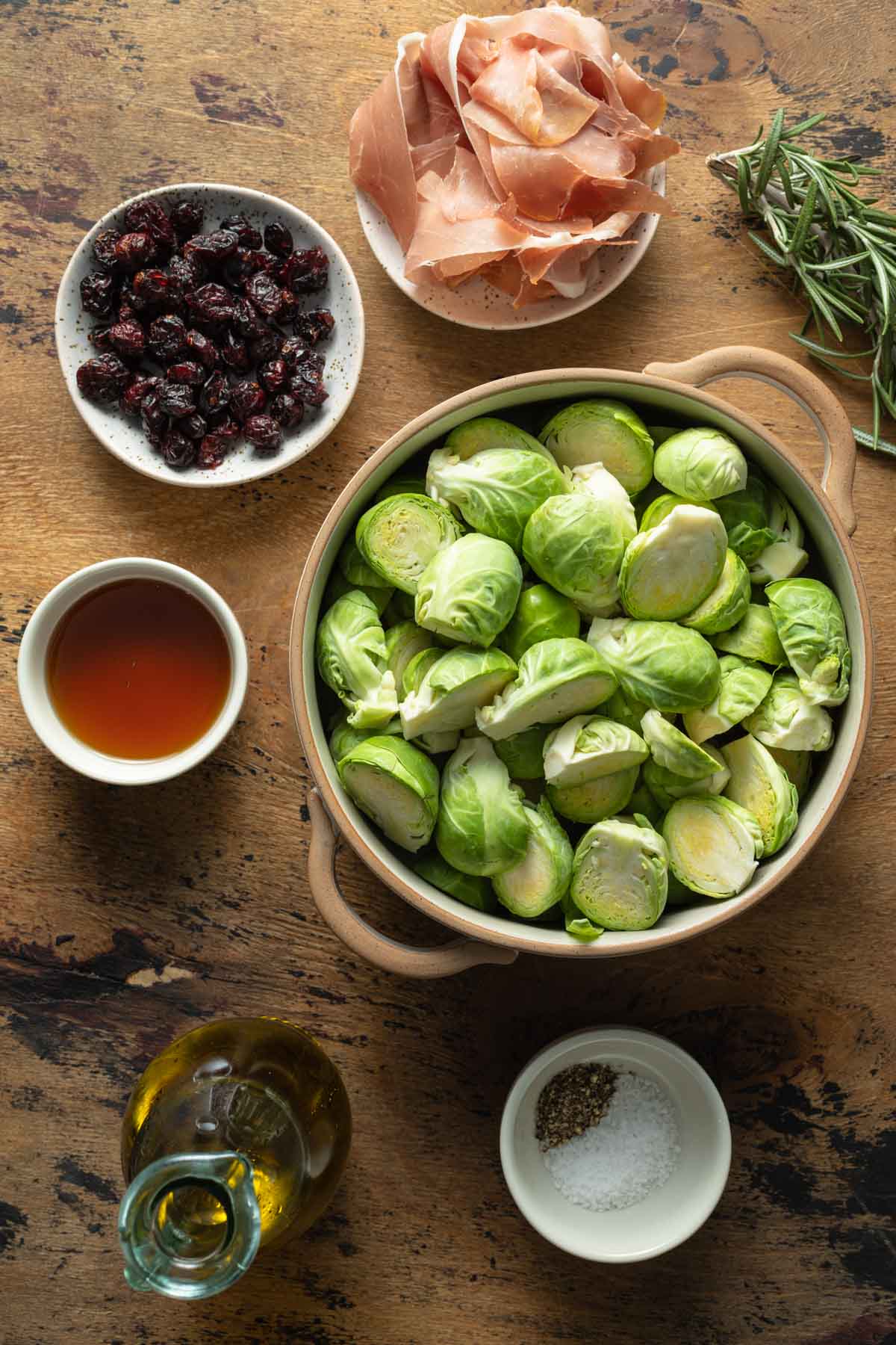 Ingredients to make roasted Brussels sprouts arranged in individual bowls.