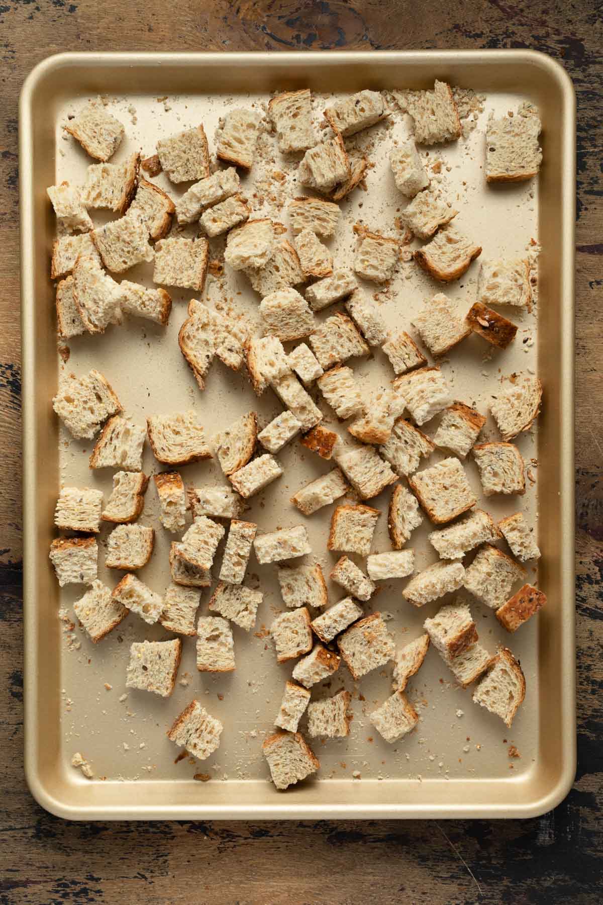 Bread cubes arranged in a single layer on a baking sheet.