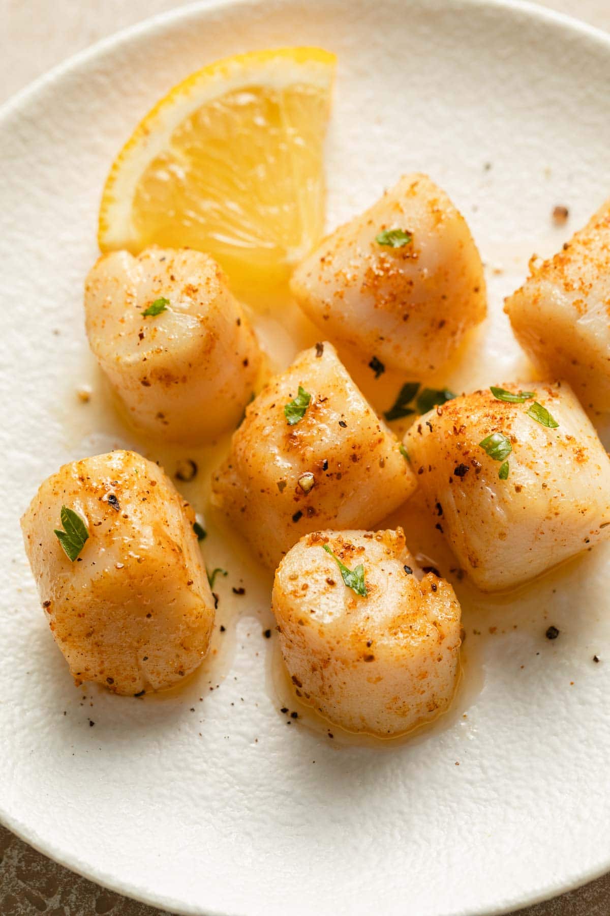 Close up of air fryer scallops on a white plate.