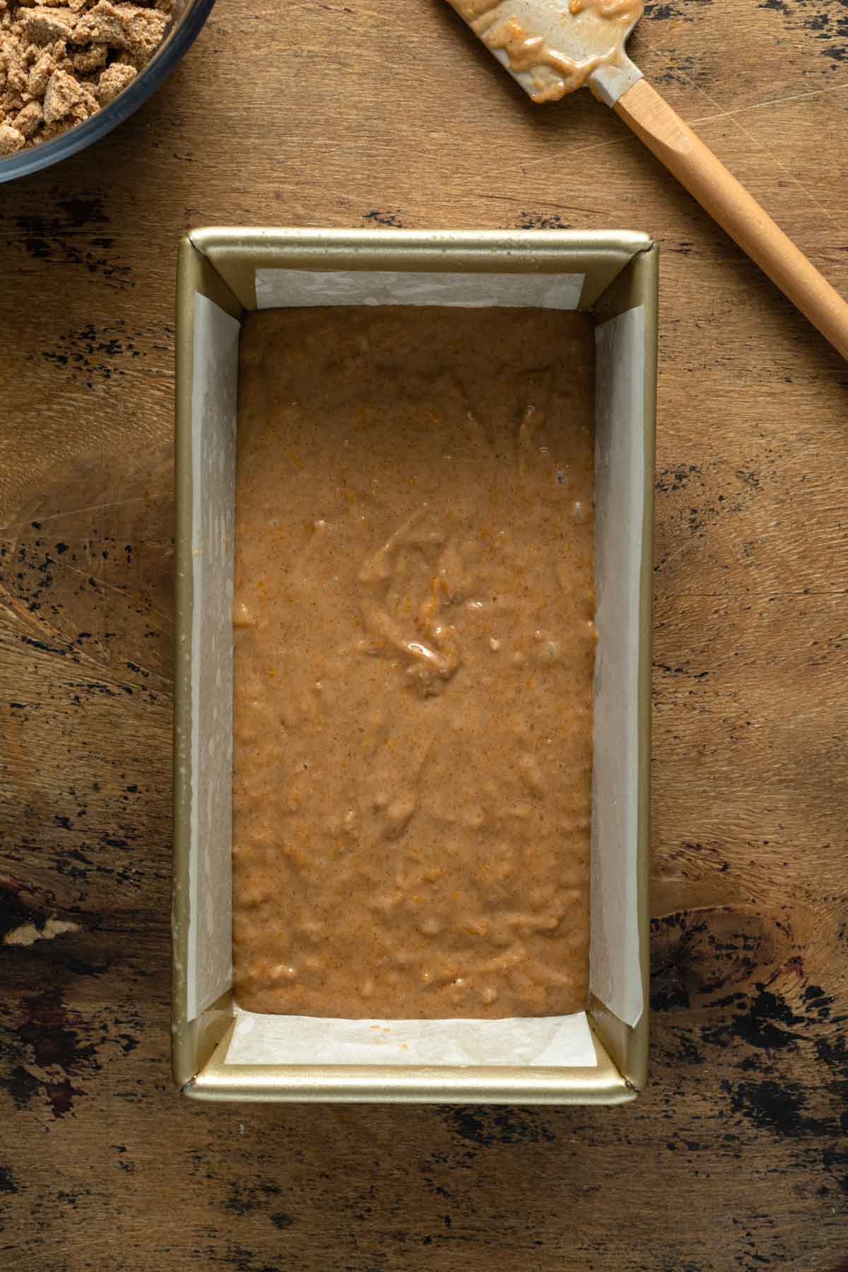 Overhead view of bread batter in a loaf pan.