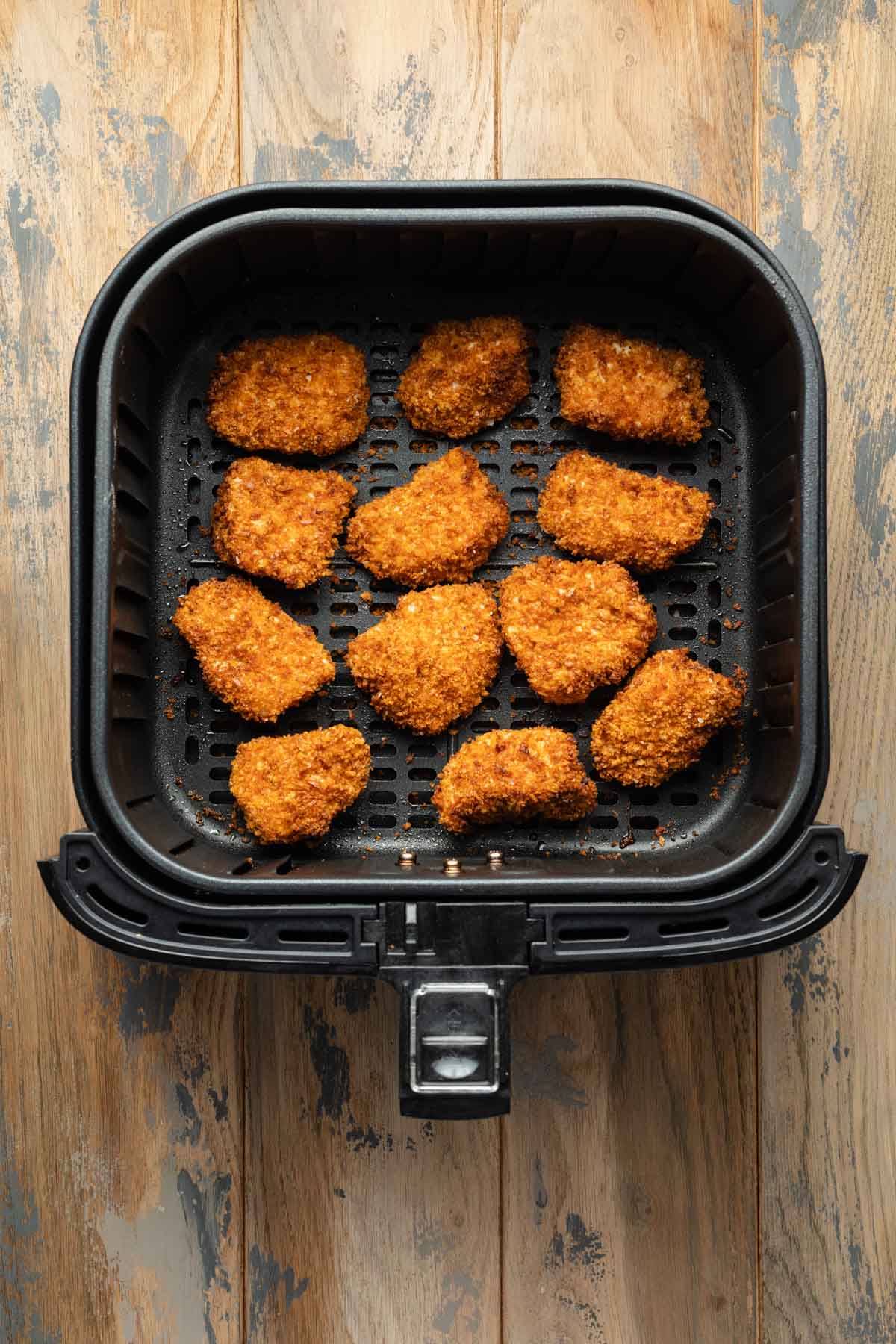 Air fried chicken nuggets in an air fryer basket.